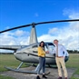 lady and man shaking hands in front of silver helicopter 